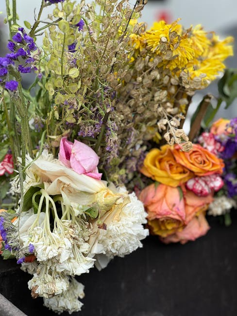 A close-up of several floral arrangements featuring a variety of flowers including white carnations, pale pink roses, purple statice, and yellow chrysanthemums, with some dried and wilted blooms mixed